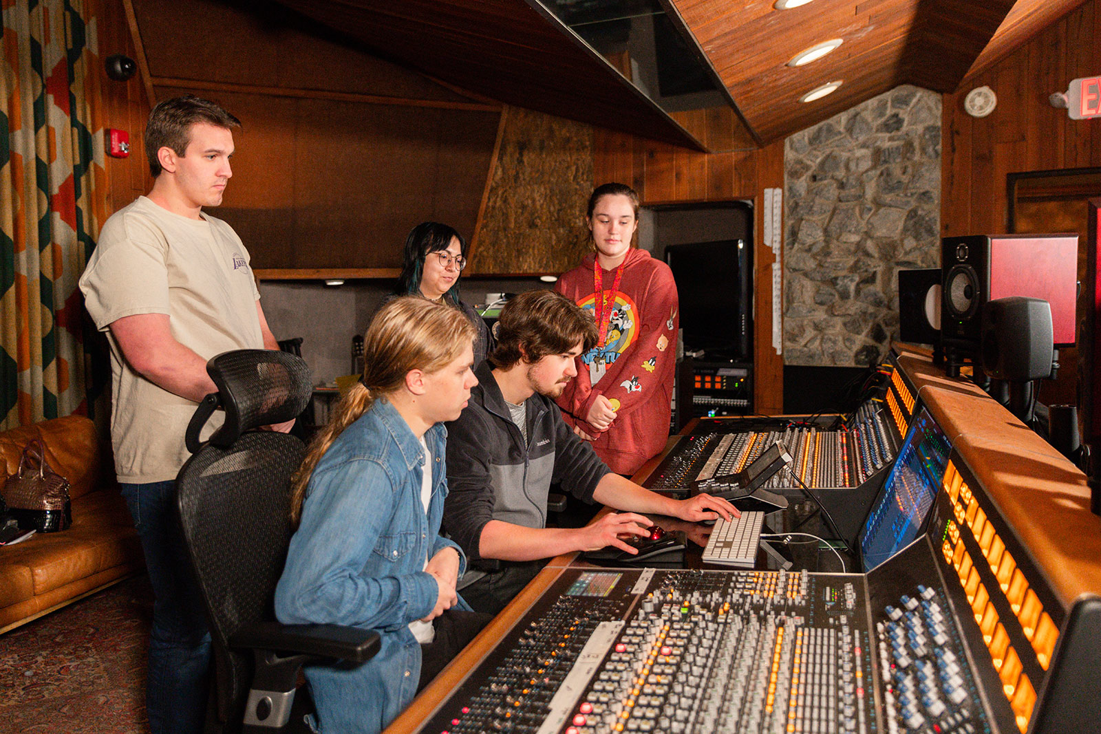 Students learning on the control room sound board