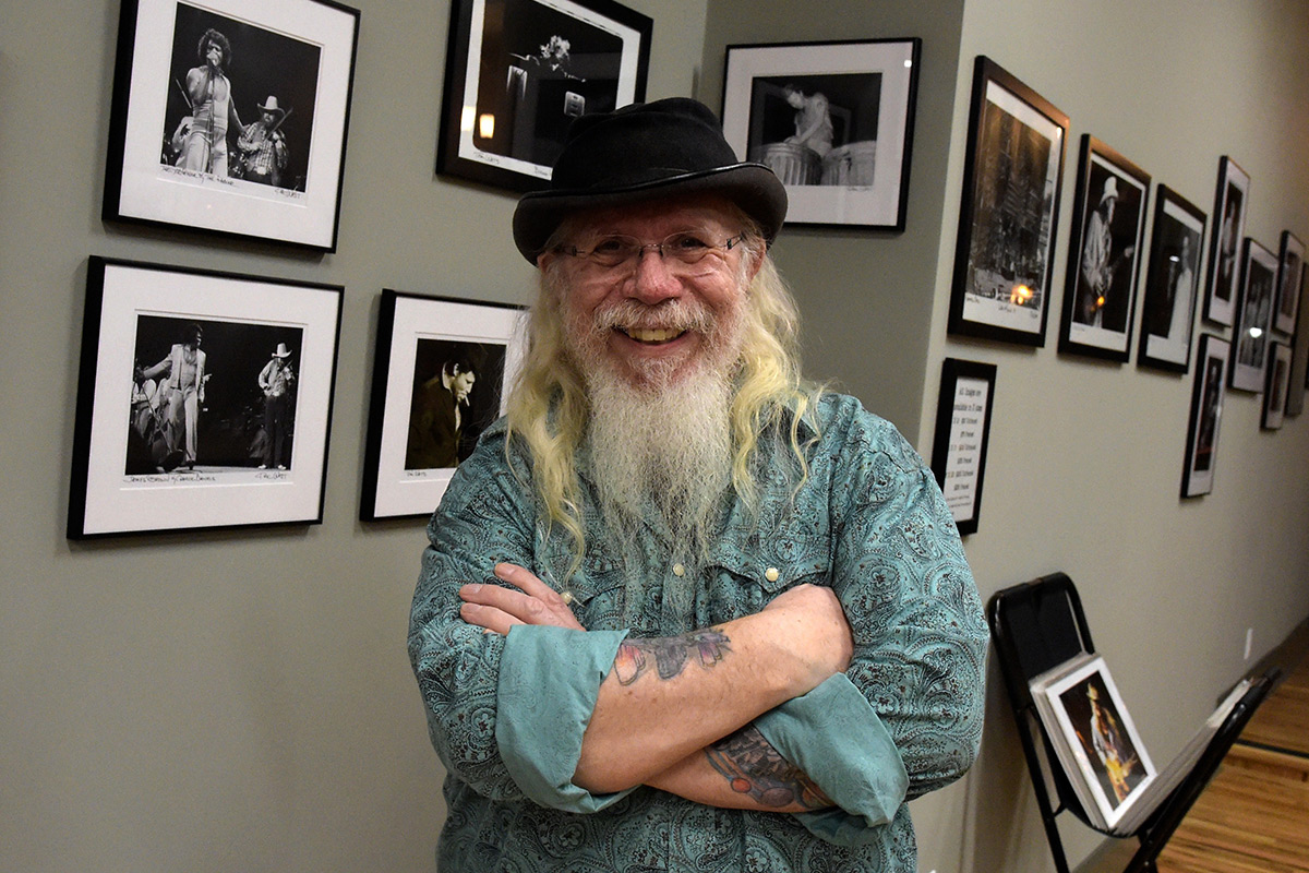 Kirk West stands in front of his framed photography